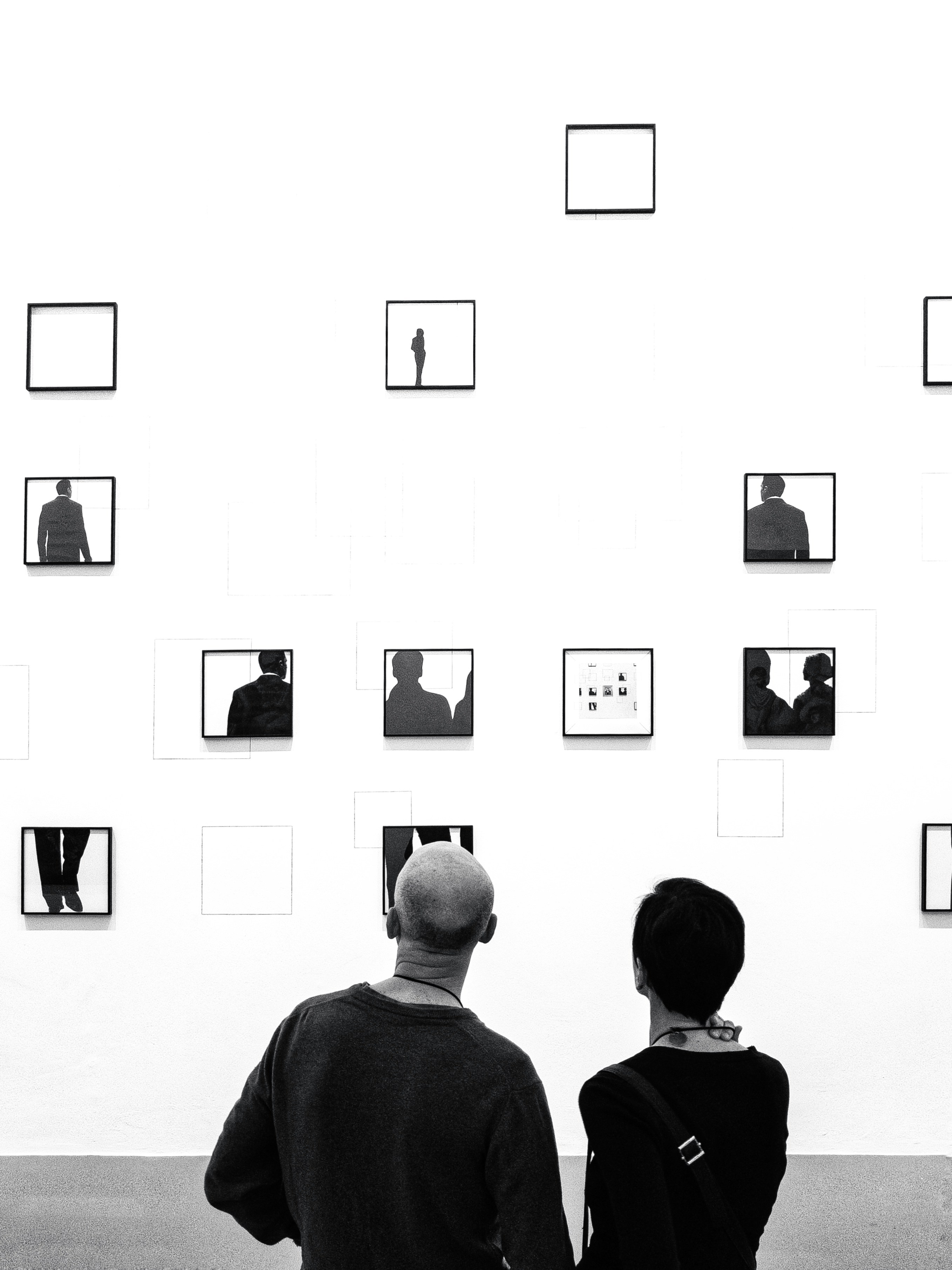 Visitors studying framed works in a gallery